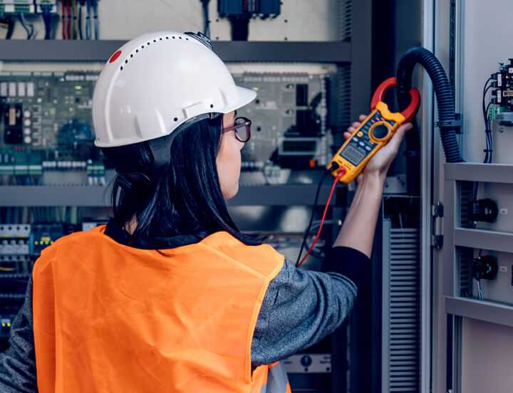 Operaria revisando cuadro eléctrico